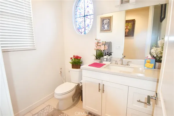 a view of a hallway with wooden floor and a bathroom