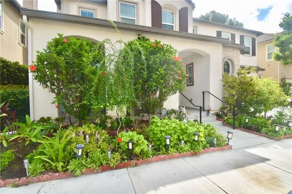 front view of a house with a small yard and potted plants