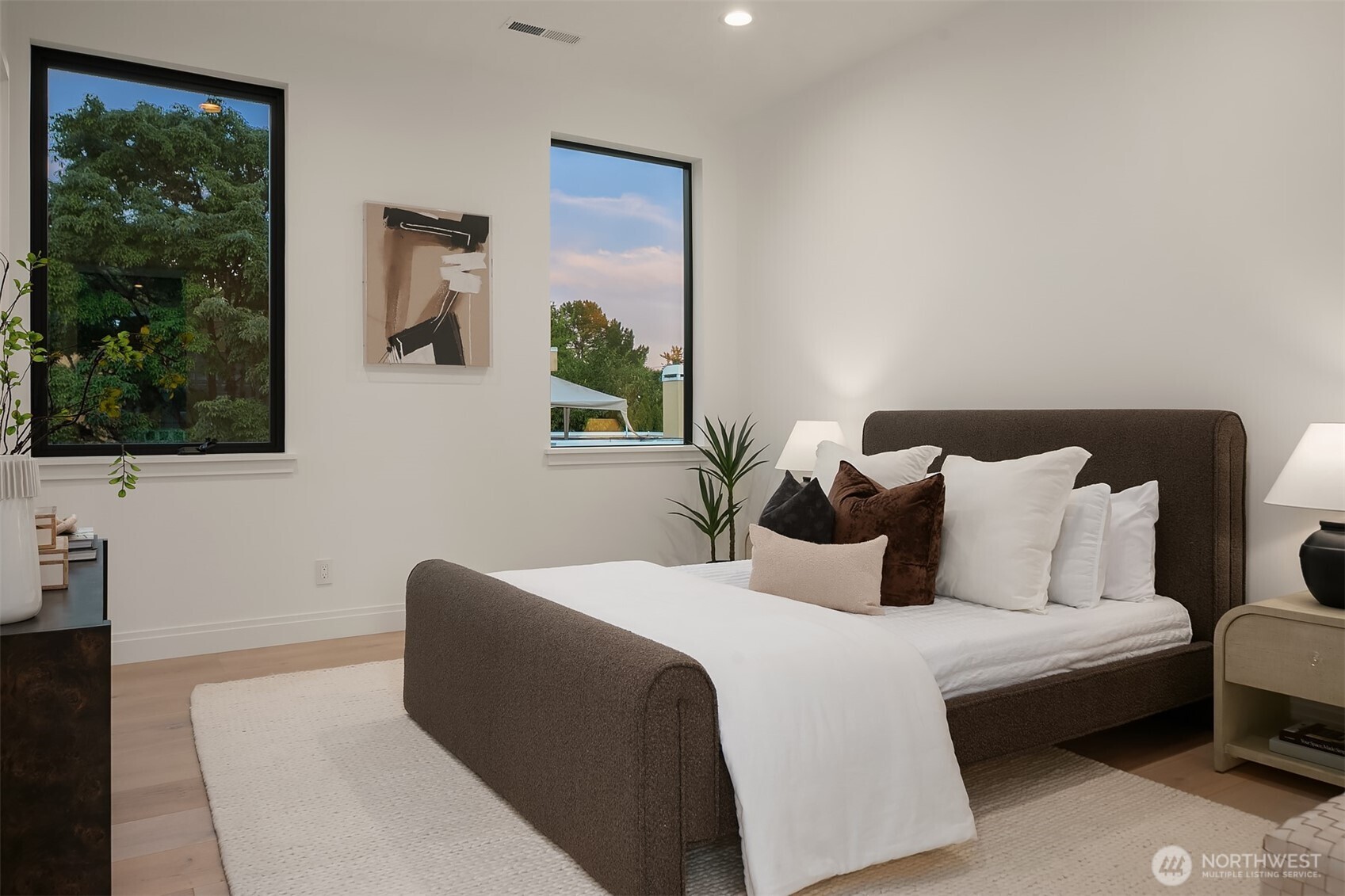 7626 Northeast 10th Street Medina, WA 98039 - Photo 26 of 40 a bedroom with a large bed and a potted plant