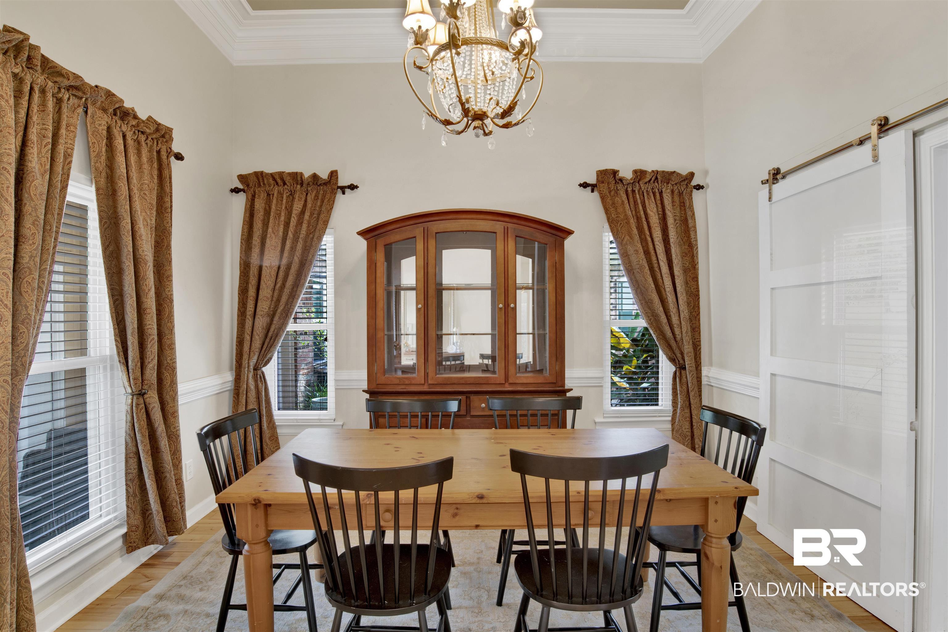 638 Southern Way Daphne, AL 36527 - Photo 12 of 26 Dining area featuring ornamental molding, light hardwood / wood-style flooring, and a notable chandelier