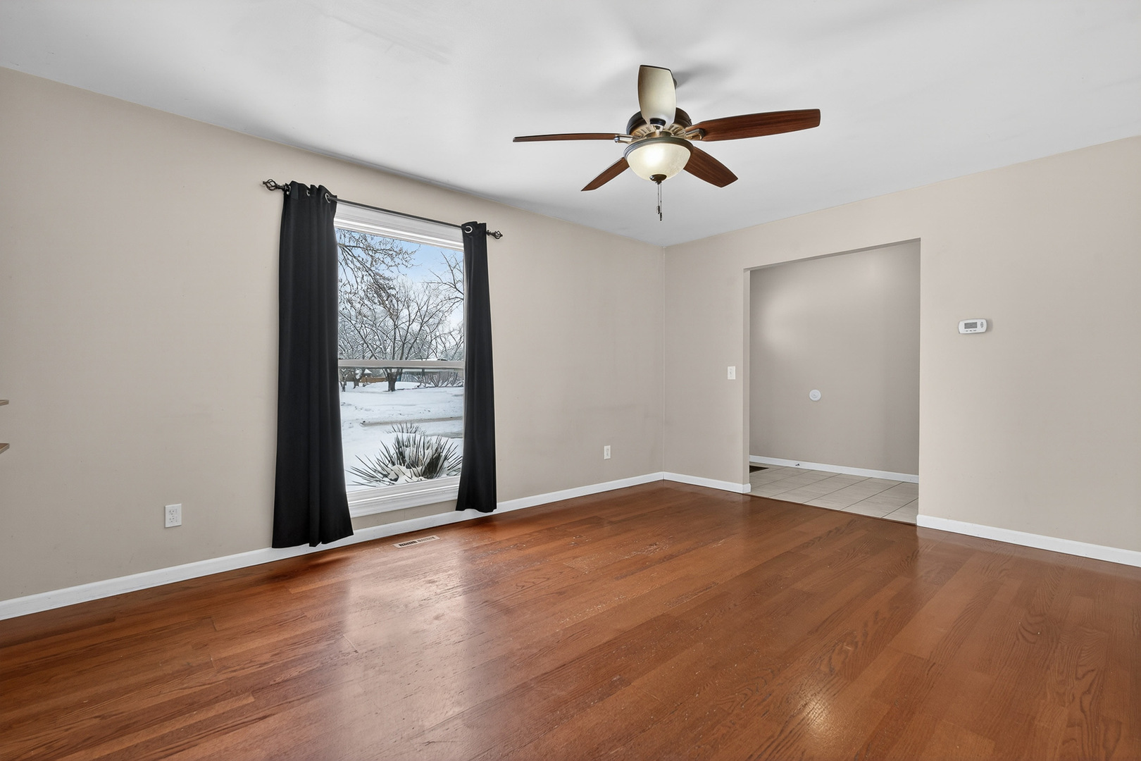73 Ingleshire Road Montgomery, IL 60538 - Photo 3 of 22 a view of an empty room with wooden floor and a window