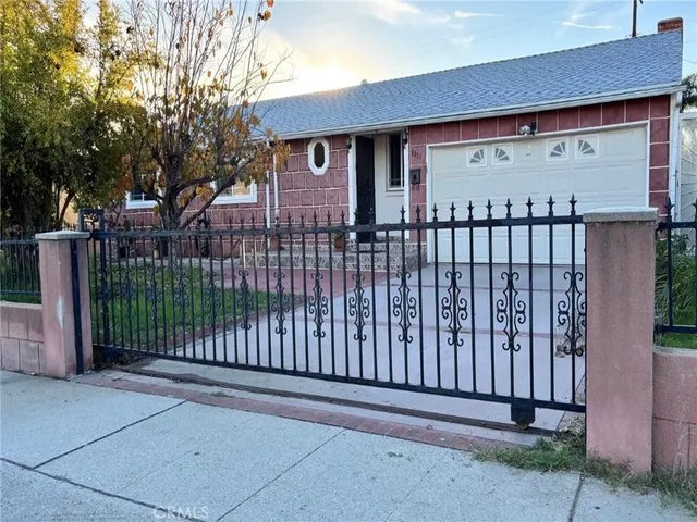 a view of a house with a small yard and wooden fence