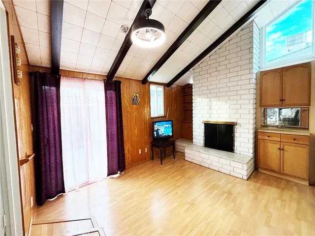 a view of an empty room with a fireplace and a window