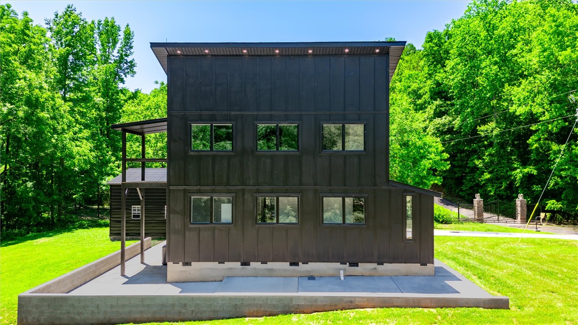 Modern architecture meets natural serenity in this striking, black-clad residence nestled among lush greenery.