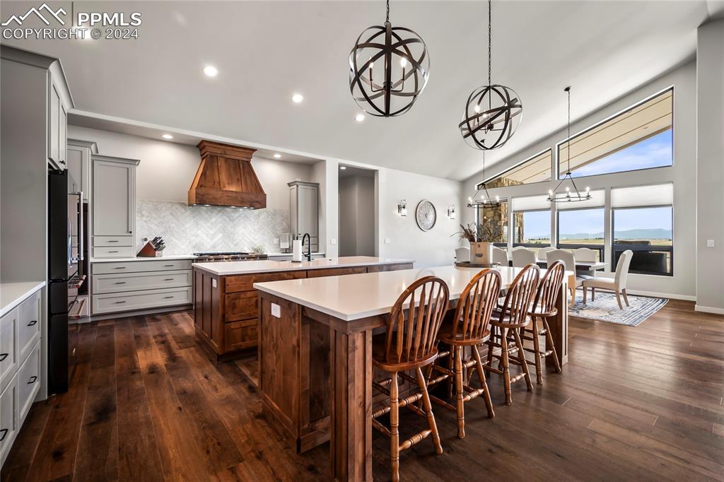 24365 Murphy Road Calhan, CO 80808 - Photo 17 of 50 a kitchen with stainless steel appliances kitchen island granite countertop a table chairs in it and wooden floors