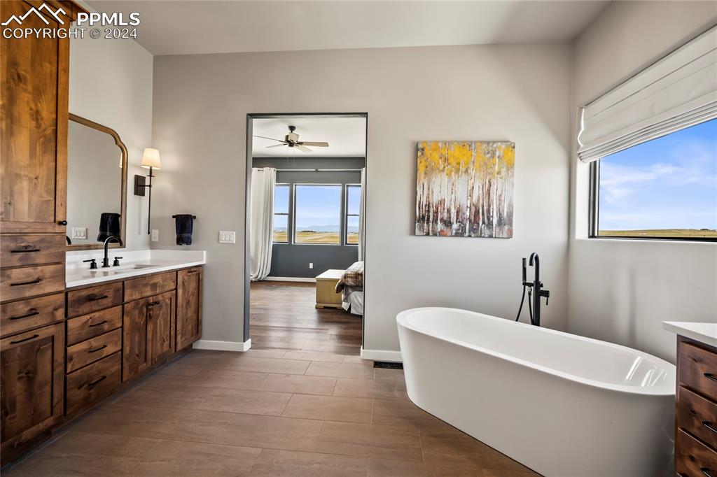 24365 Murphy Road Calhan, CO 80808 - Photo 33 of 50 a bathroom with a double vanity sink a mirror a bathtub and window