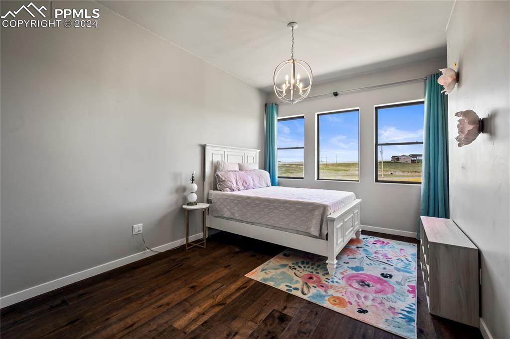 24365 Murphy Road Calhan, CO 80808 - Photo 35 of 50 a bedroom with a bed chandelier and a window