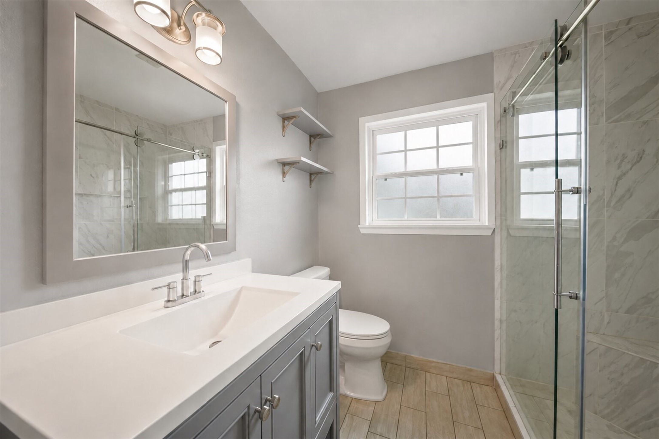 1306 Camden Road Pasadena, TX 77502 - Photo 11 of 16 Beautifully updated full bathroom featuring a modern gray vanity, white countertop, sleek fixtures, and a stunning walk in glass shower with tile surround.