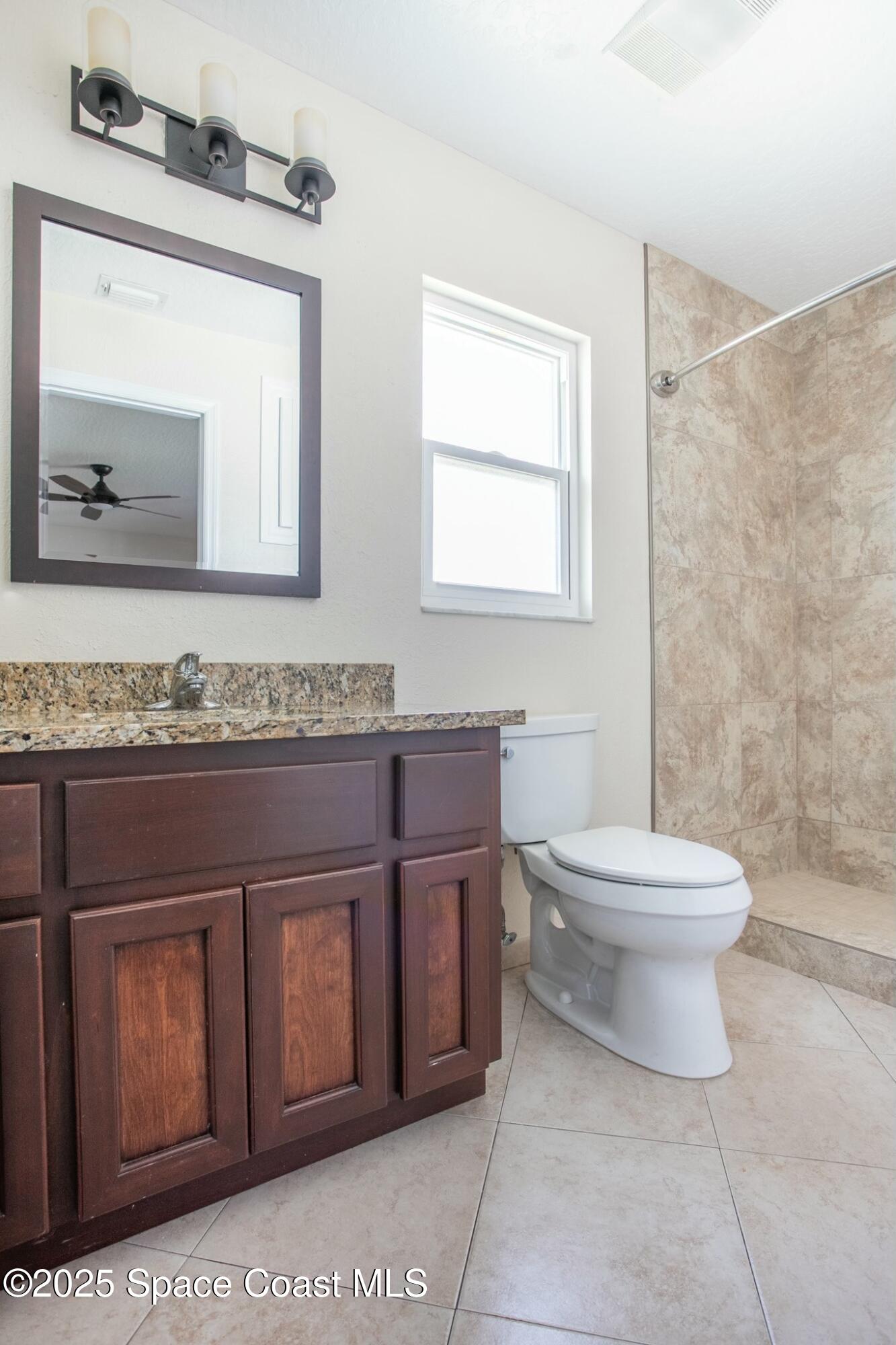 6485 Orchid Avenue Cocoa, FL 32927 - Photo 15 of 24 a bathroom with a toilet a sink and mirror
