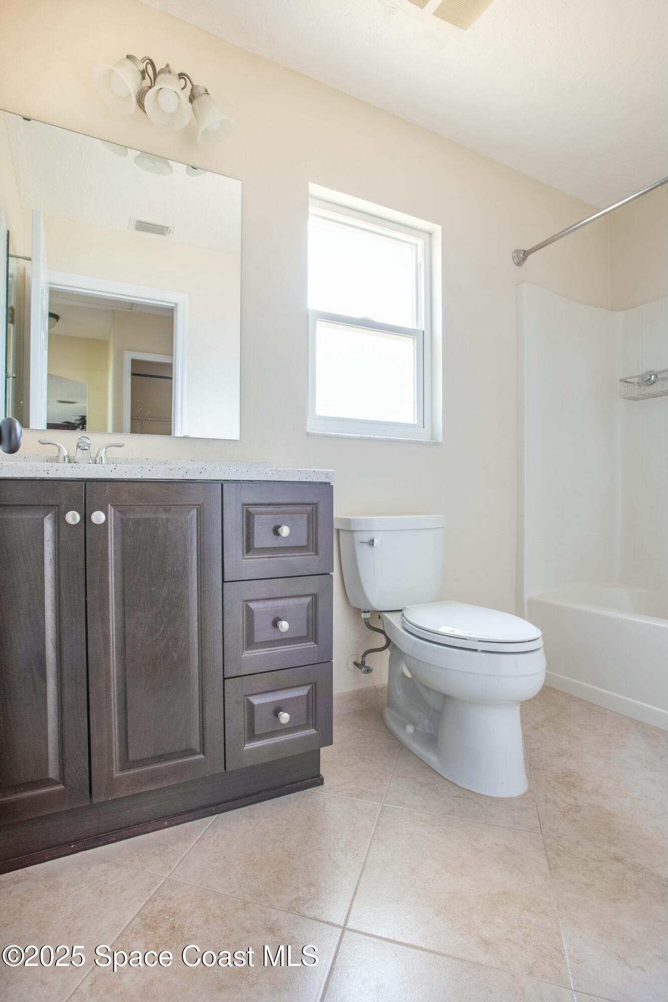 6485 Orchid Avenue Cocoa, FL 32927 - Photo 23 of 24 a bathroom with a toilet a sink and mirror