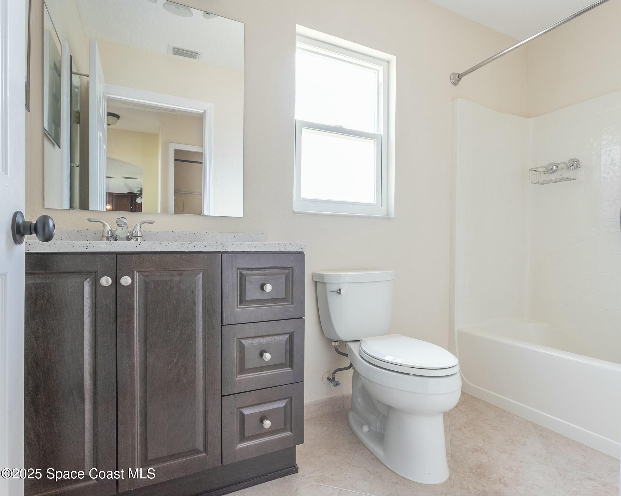 6485 Orchid Avenue Cocoa, FL 32927 - Photo 24 of 24 a bathroom with a granite countertop toilet sink and mirror