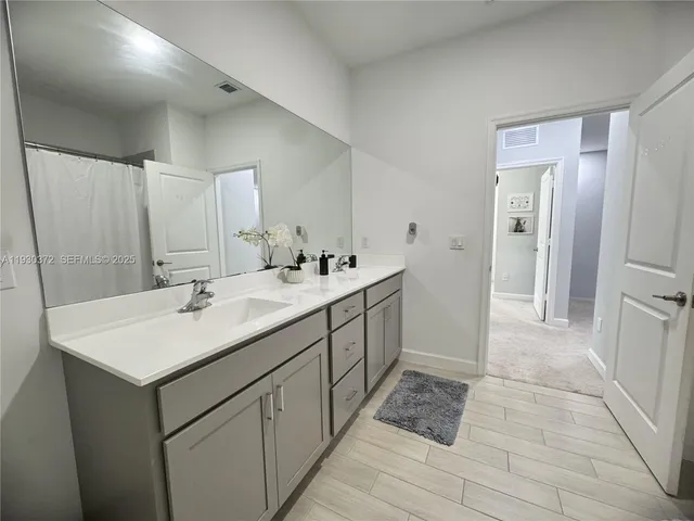a bathroom with a double vanity sink and mirror