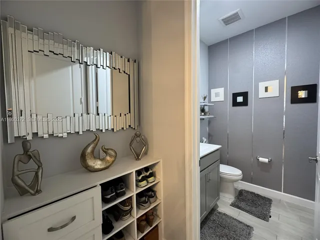 a kitchen with stainless steel appliances kitchen island granite countertop a dining table chairs refrigerator sink and cabinets