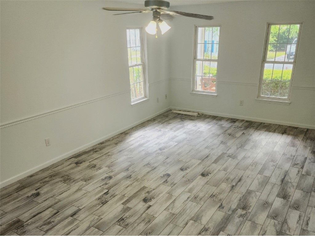 328 Springfield Circle Easley, SC 29642 - Photo 12 of 29 A well-lit room showcases durable plank flooring under a functional ceiling fan.