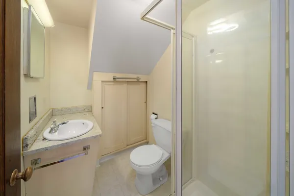 a bathroom with a granite countertop toilet a sink and a mirror