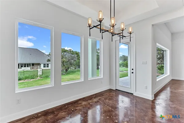 a view of a livingroom with a floor to ceiling window and chandelier