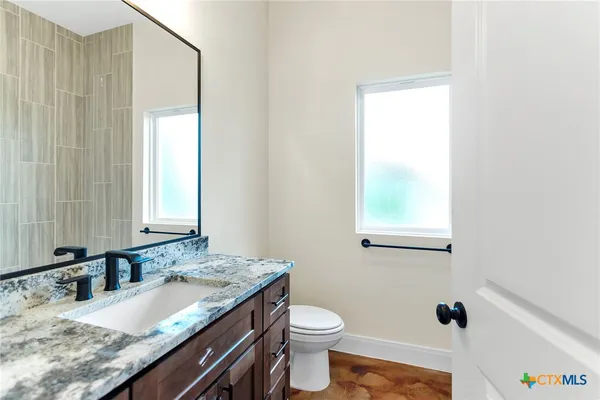 a bathroom with a granite countertop sink and a mirror