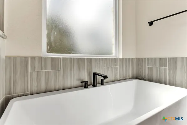 a bathroom with a bathtub and a window
