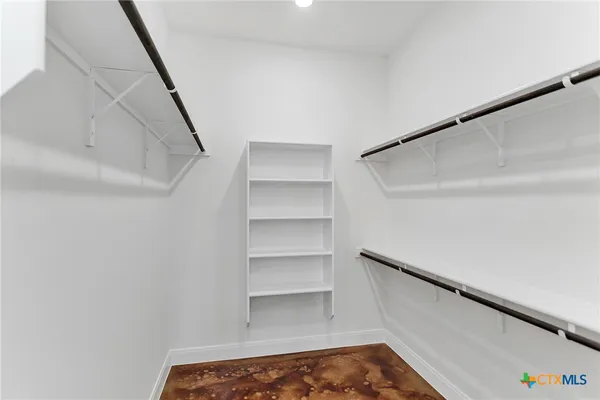 a view of walk in closet with empty racks
