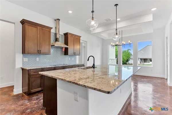 a kitchen with stainless steel appliances granite countertop a sink a center island and cabinets