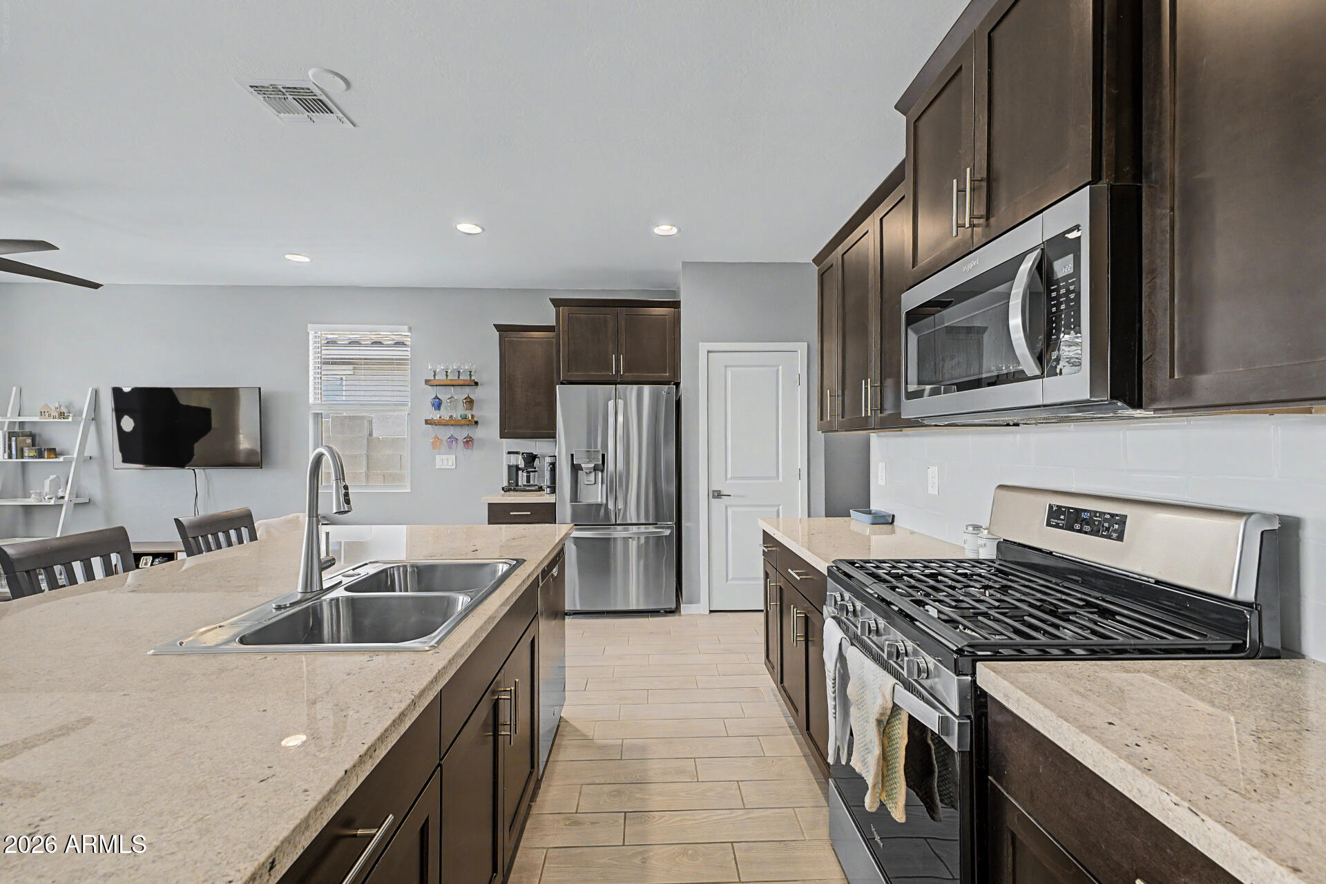6773 West Trumbull Road Phoenix, AZ 85043 - Photo 11 of 30 a kitchen with stainless steel appliances granite countertop a sink stove and refrigerator