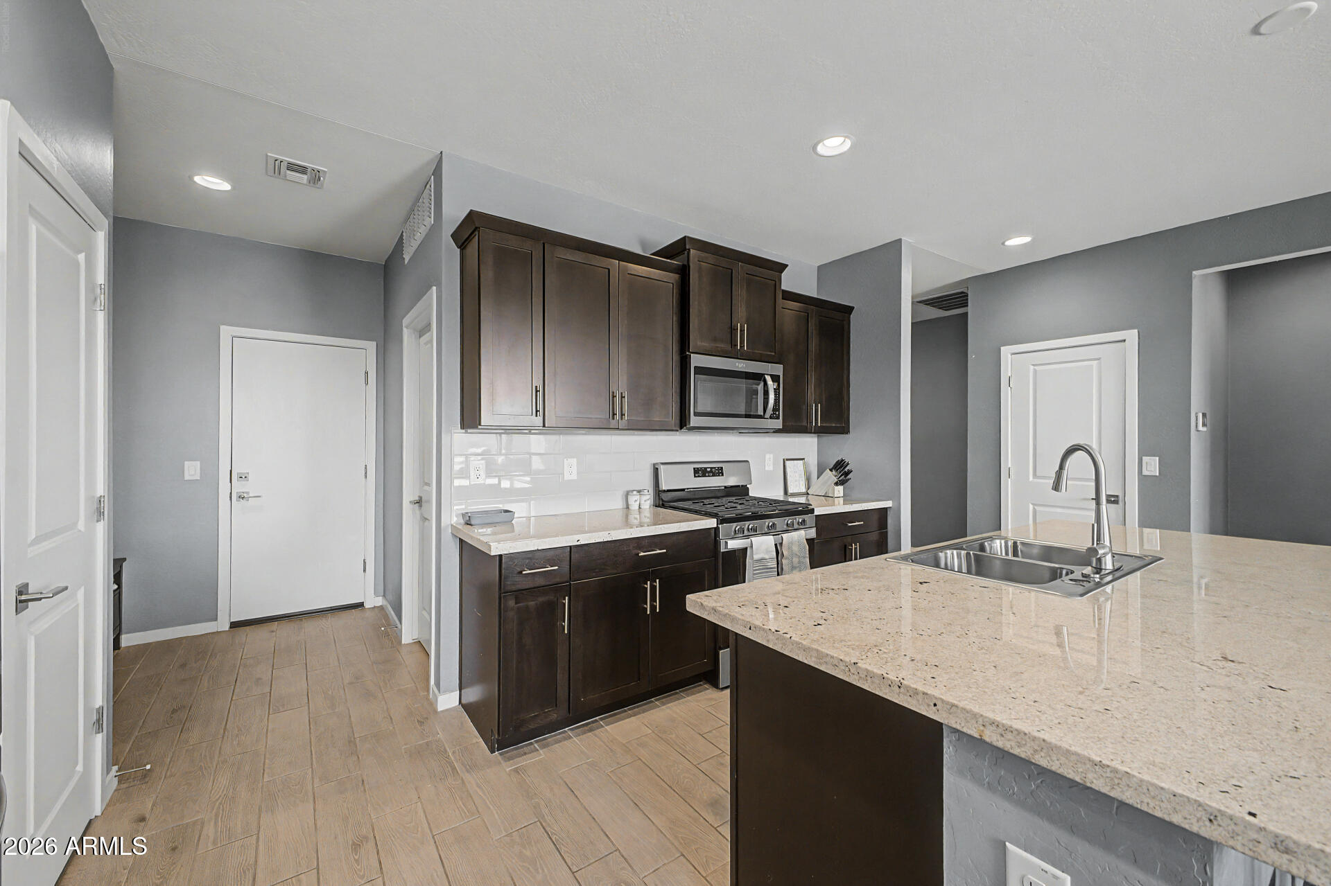 6773 West Trumbull Road Phoenix, AZ 85043 - Photo 12 of 30 a kitchen with stainless steel appliances granite countertop a sink stove and refrigerator