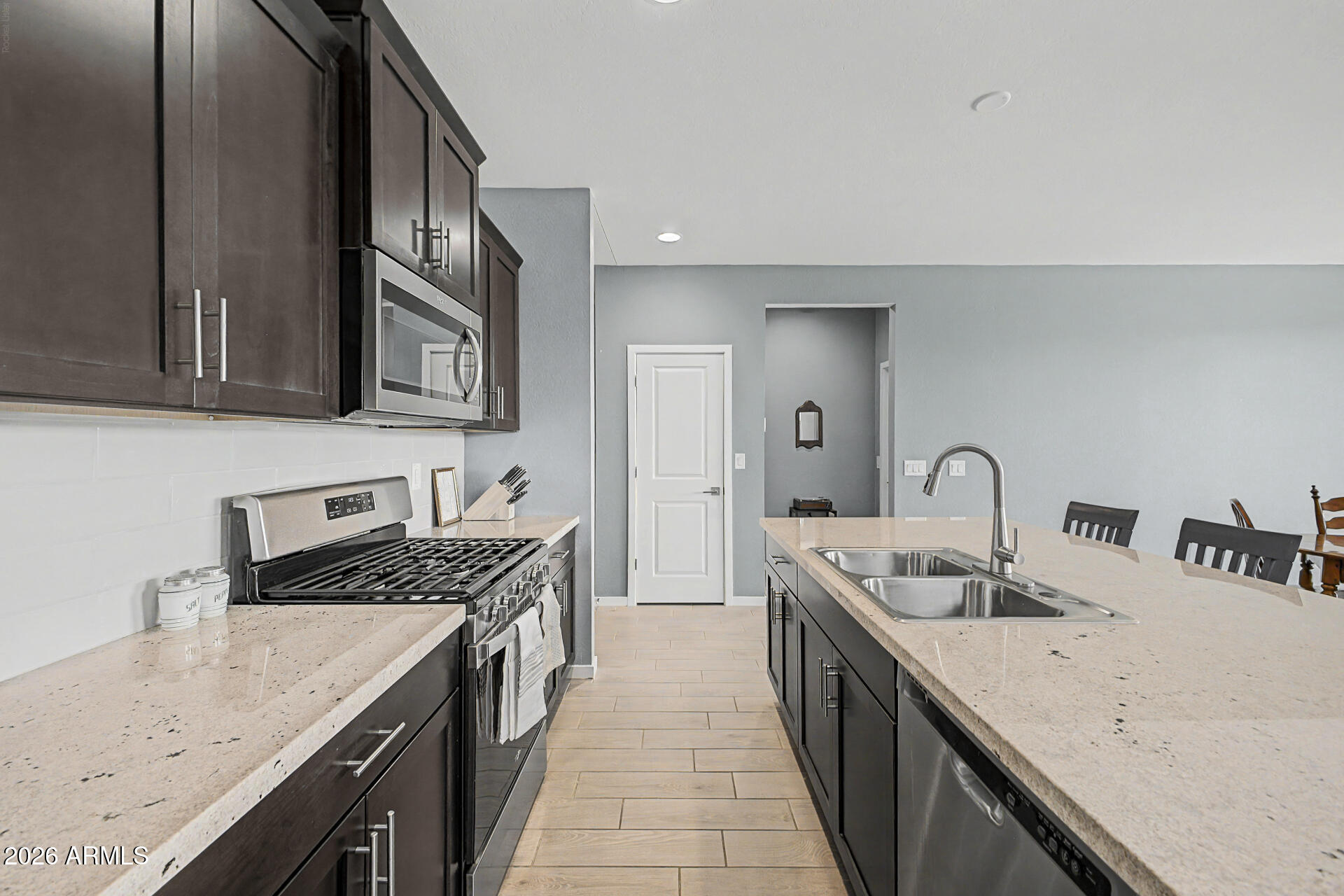 6773 West Trumbull Road Phoenix, AZ 85043 - Photo 13 of 30 a kitchen with stainless steel appliances granite countertop a sink stove and cabinets