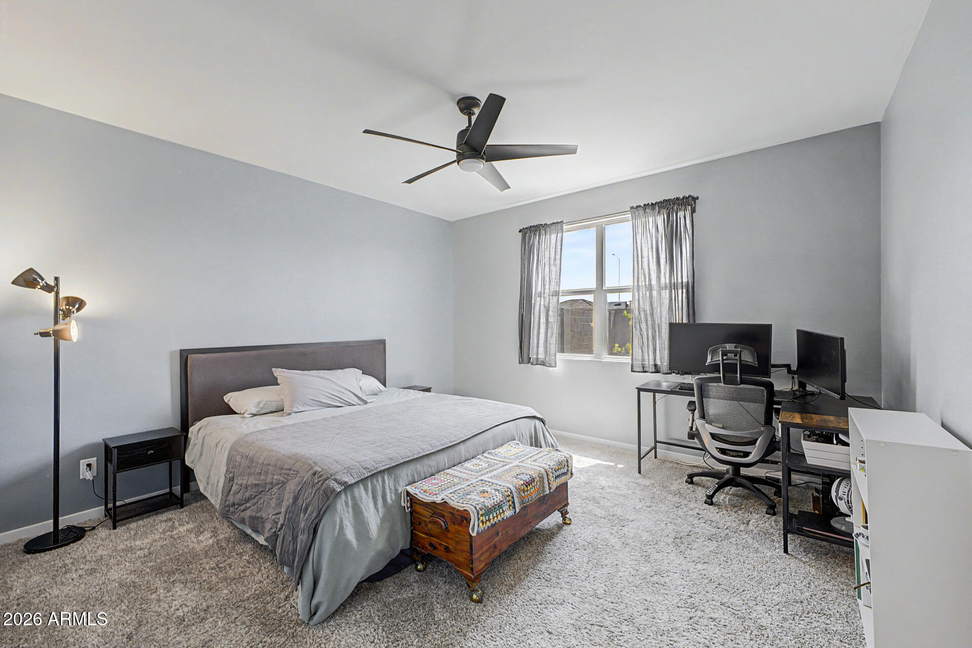 6773 West Trumbull Road Phoenix, AZ 85043 - Photo 14 of 30 a bedroom with a bed a desk and a window