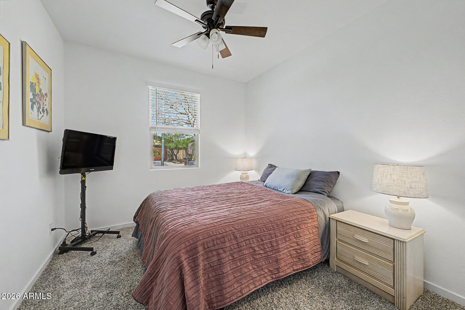 6773 West Trumbull Road Phoenix, AZ 85043 - Photo 19 of 30 a bedroom with a bed and a flat screen tv