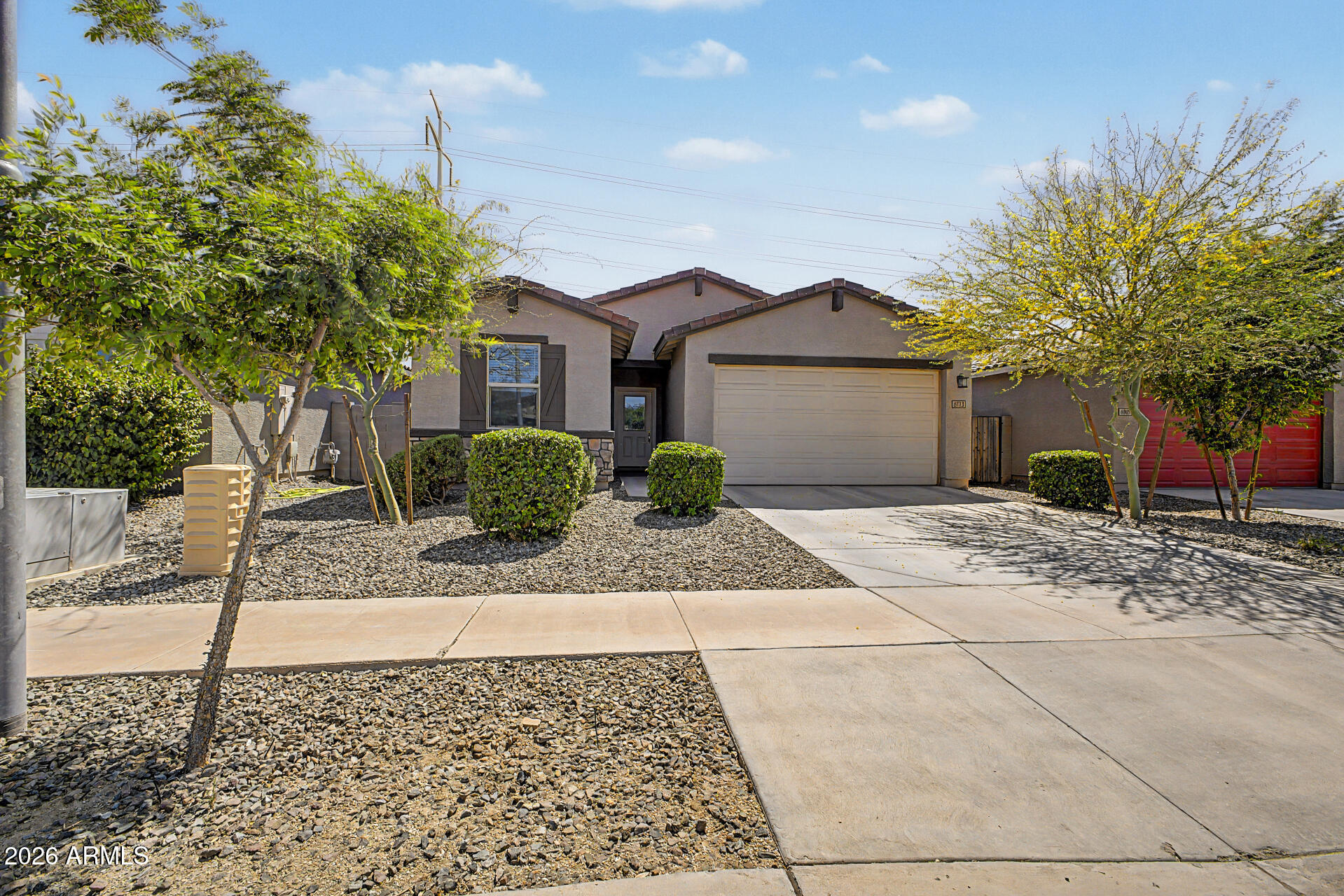 6773 West Trumbull Road Phoenix, AZ 85043 - Photo 2 of 30 a front view of a house with a yard and trees