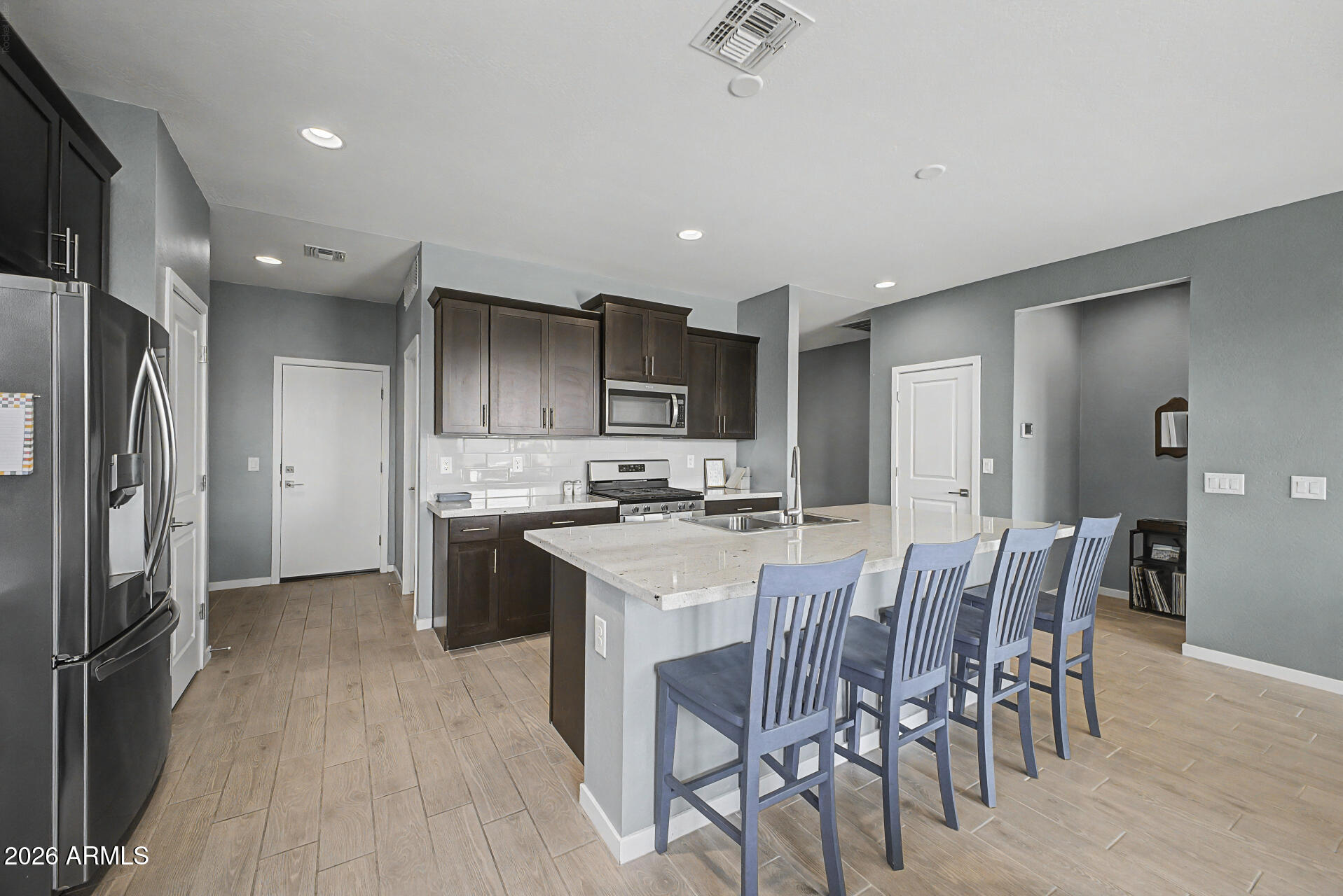6773 West Trumbull Road Phoenix, AZ 85043 - Photo 9 of 30 a kitchen with a table chairs refrigerator and cabinets