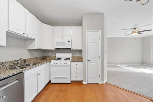 a view of a big room with windows and ceiling fan