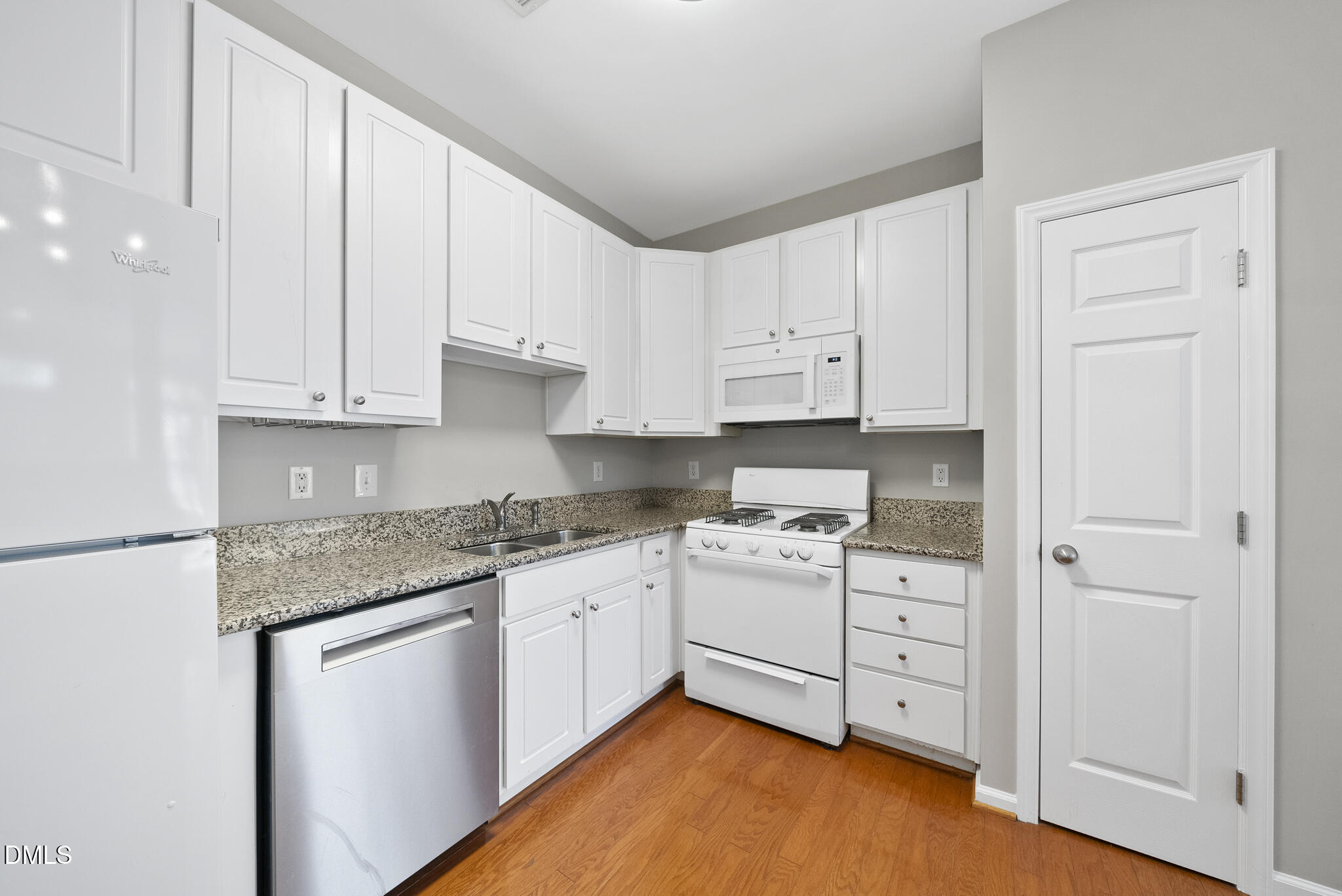 2211 Raven Road, Unit 102 Raleigh, NC 27614 - Photo 10 of 30 a kitchen with stainless steel appliances granite countertop a stove a sink and white cabinets with wooden floor