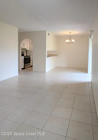 a view of a kitchen with furniture and an empty room