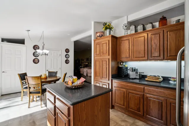 a kitchen with granite countertop a refrigerator and a stove top oven