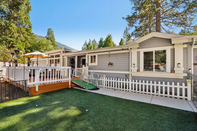 a view of a house with a yard and deck