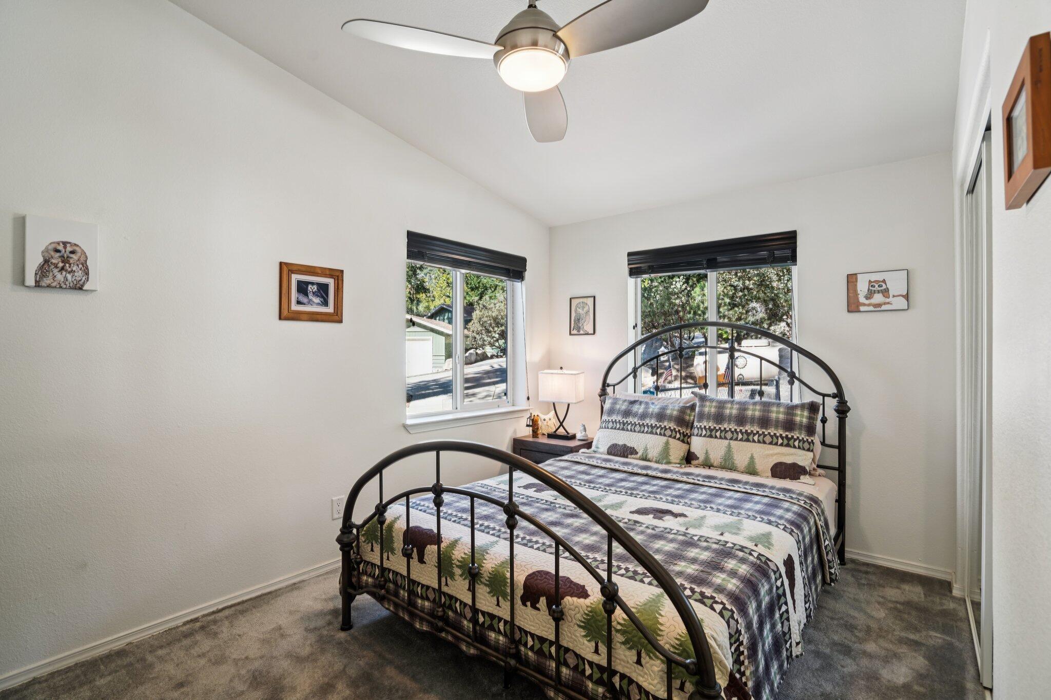 25001 Rim Rock Road Idyllwild, CA 92549 - Photo 36 of 49 a bedroom with a bed window and a chandelier