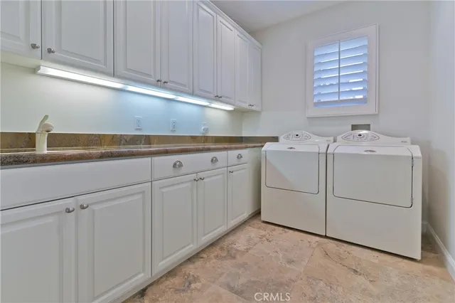 a utility room with cabinets washer and dryer