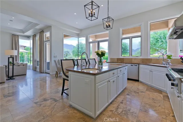 a large kitchen with kitchen island a large counter space a sink a window and stainless steel appliances