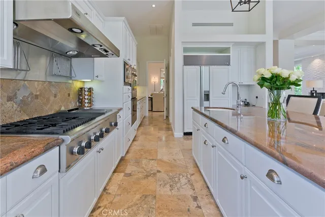 a large kitchen with stainless steel appliances granite countertop a stove and a sink