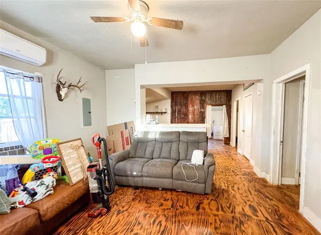 a view of a hallway with wooden floor and a bathroom