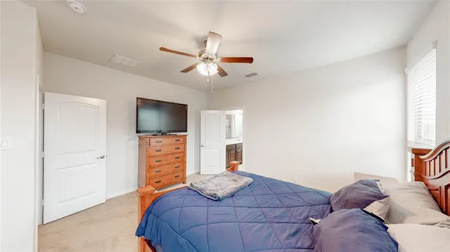 a bedroom with a large bed and a flat screen tv