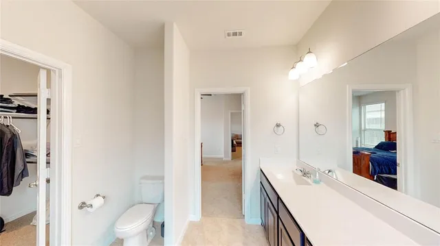 a en suite bathroom with a double vanity sink a mirror and a toilet