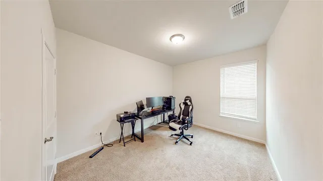 a view of a workspace with furniture and a window