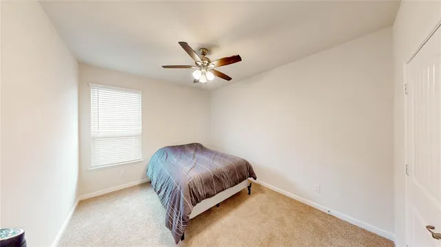 an empty room with a ceiling fan and a window