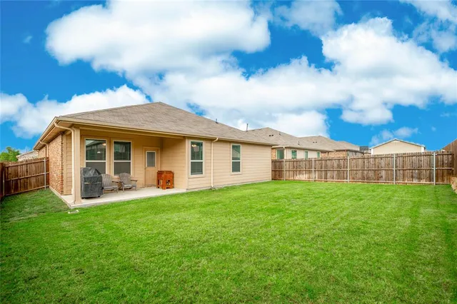 a view of a house with a yard and sitting area