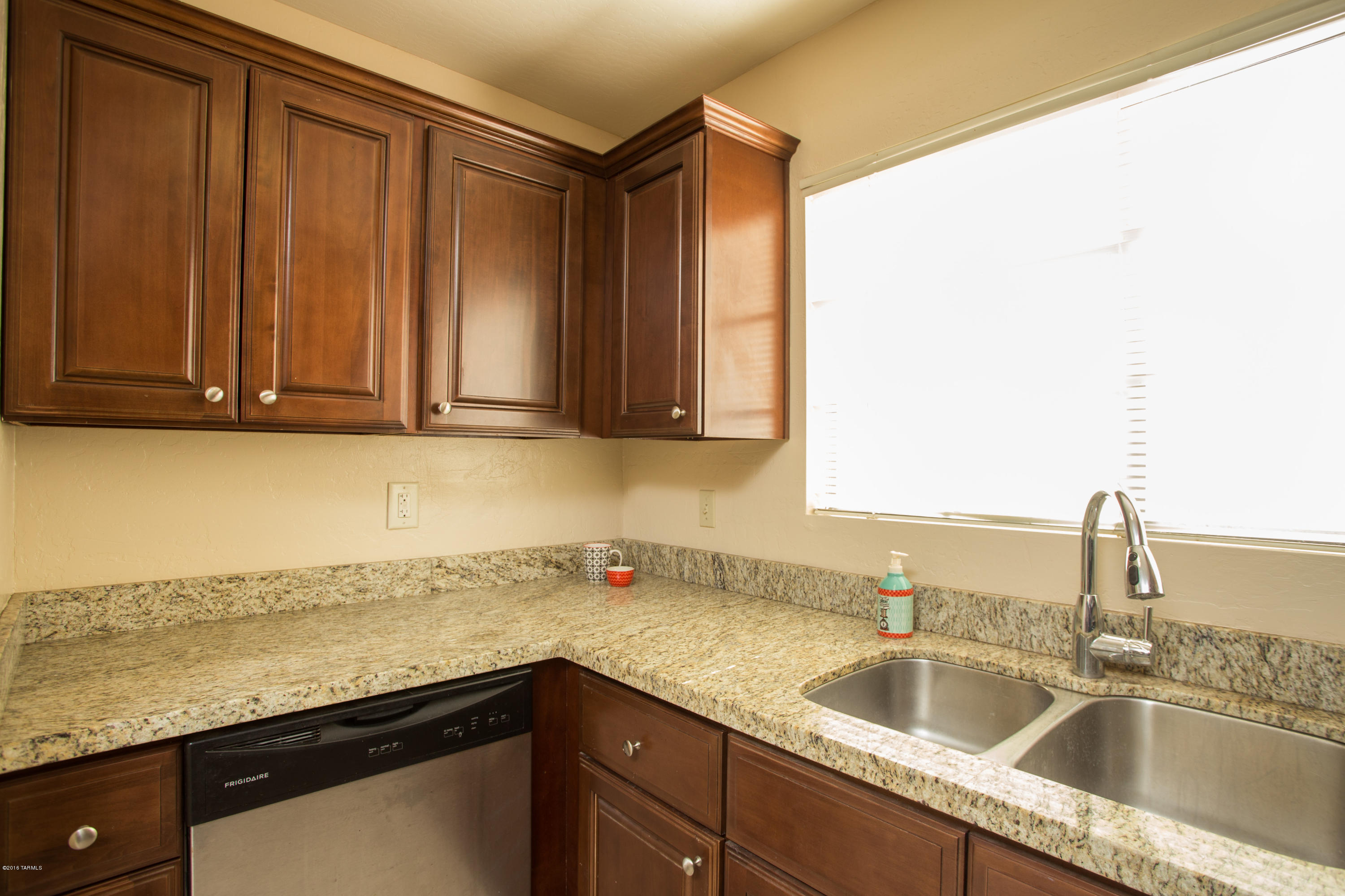 242 East Pastime Road Tucson, AZ 85705 - Photo 10 of 20 a kitchen with granite countertop a sink and a wooden cabinets