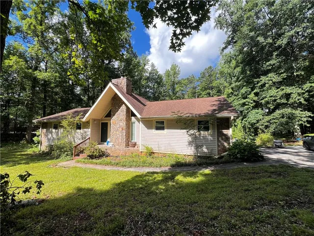 a front view of a house with yard and green space
