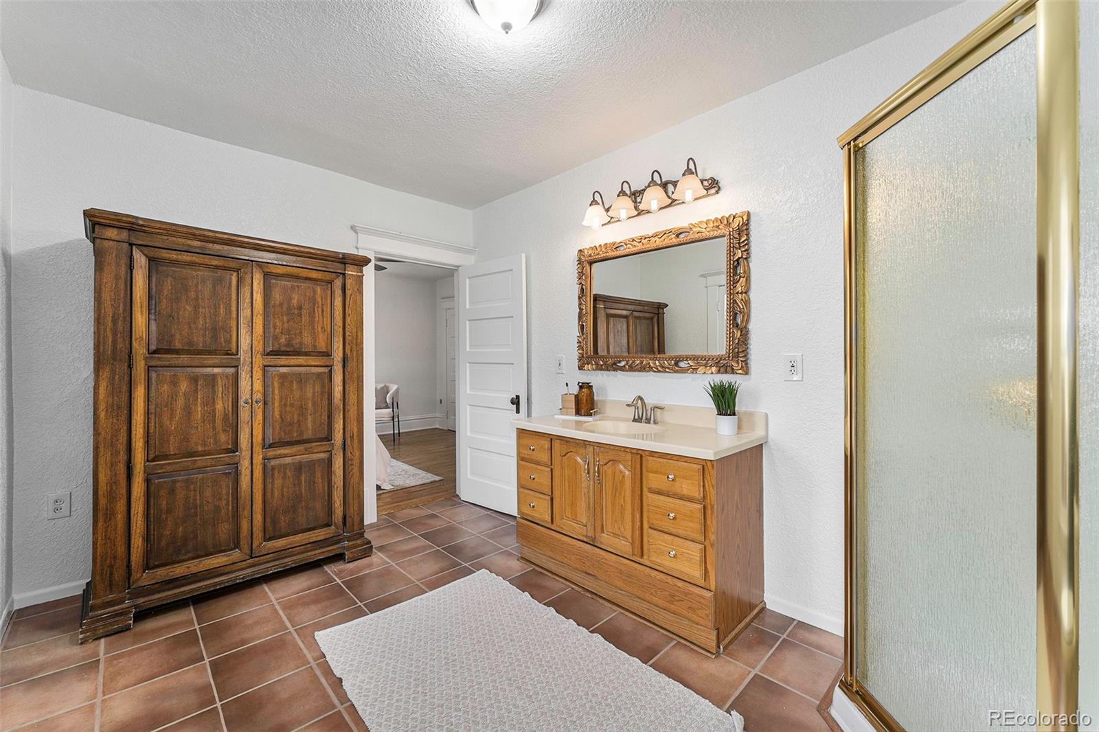 1314 Vine Street Denver, CO 80206 - Photo 16 of 34 a bathroom with a sink a mirror and a vanity
