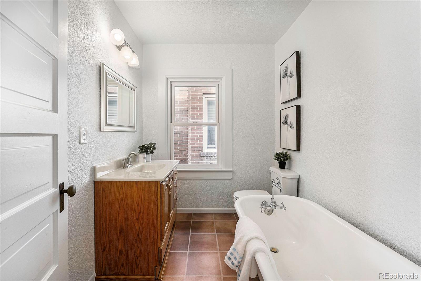 1314 Vine Street Denver, CO 80206 - Photo 21 of 34 a bathroom with a tub sink and mirror